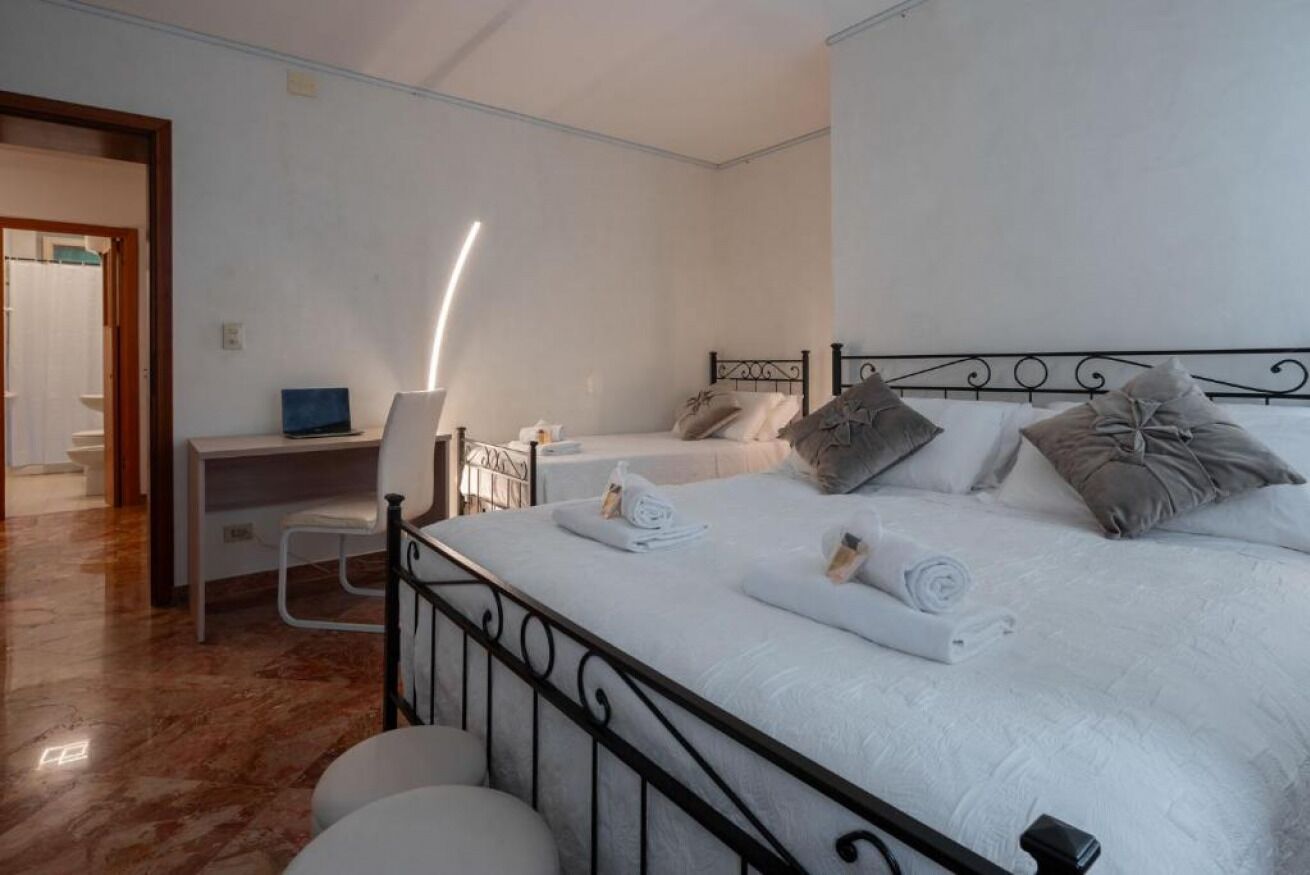 Un dormitorio con una cama, un escritorio y una silla.