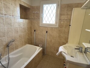 A bathroom with a bathtub, a shower, a window, and a sink. - (026) Le côté Remparts (Antibes)