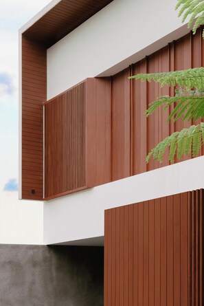 A modern building with a combination of vertical wooden panels and a white facade. - Modern 3BR Villa with private pool near Pakuwon Mall (Sleman)