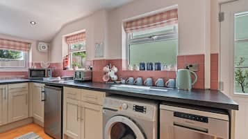 A modern kitchen with a built-in washing machine, a microwave, and a toaster.