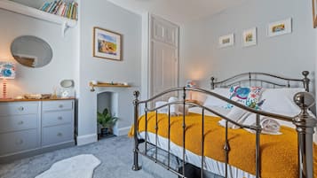 A bedroom with a bed, a dresser, a mirror, and a door.