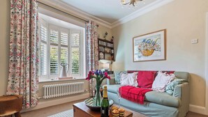 Ein gemütliches Wohnzimmer mit einer Couch, einer Holzbank und einem Fenster mit Vorhängen.
