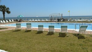 A pool area with lounge chairs and a clear view of the ocean. - Sunswept 107 by Liquid Life (Orange Beach)