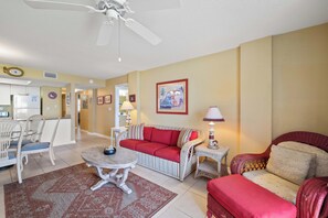 A living room with a sofa, chairs, a dining table, and a ceiling fan. - Sunswept 108 by Liquid Life (Orange Beach)
