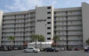 A multi-story hotel with a central entrance and balconies on each floor. - Sunswept 202 by Liquid Life (Orange Beach)