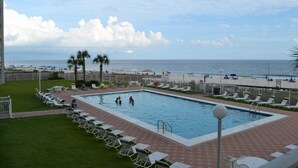 A swimming pool with lounge chairs and a view of the beach. - Sunswept 204 by Liquid Life (Orange Beach)