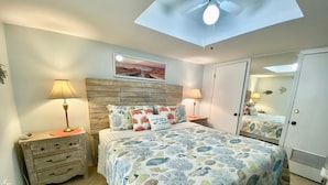 A bedroom with a bed, bedside tables, a ceiling fan, a wall-mounted picture, and a wardrobe. - Sunswept 204 by Liquid Life (Orange Beach)