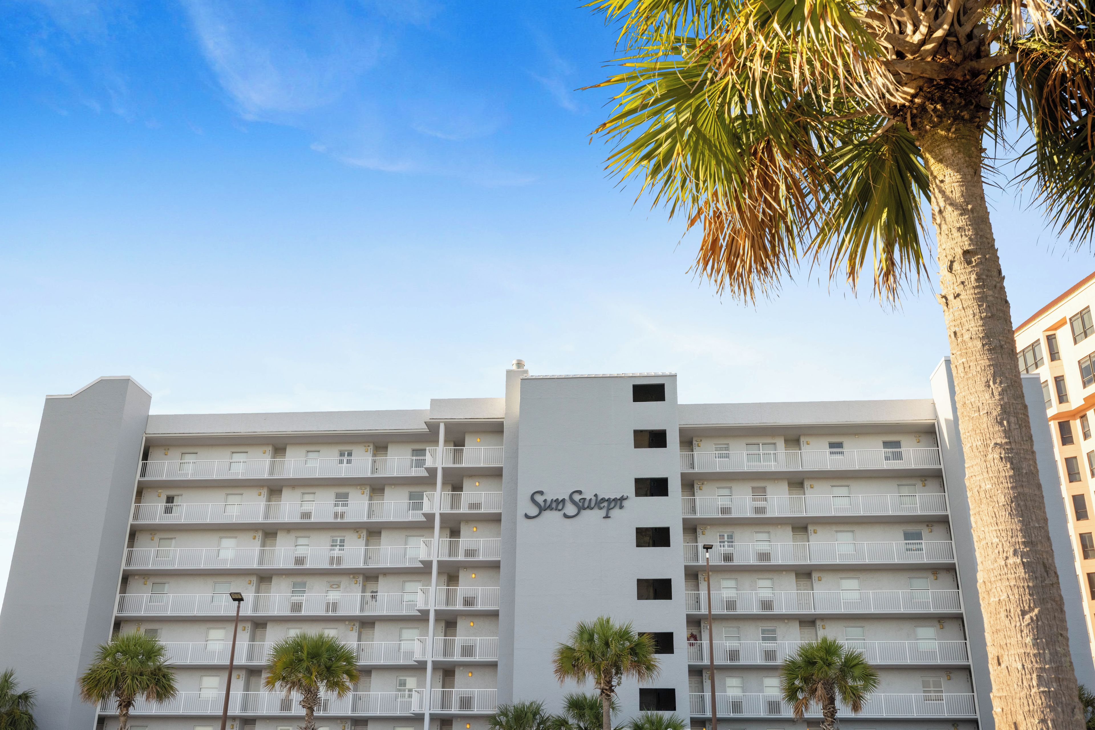 Un edificio de hotel de varios pisos con un letrero llamativo que dice 'SumSwept'.