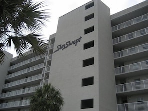 A multi-story hotel building with the name 'SunSept' on the facade. - Sunswept 208 by Liquid Life (Orange Beach)