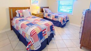 Un dormitorio con dos camas, cada una con una colcha acolchada de temática patriótica.