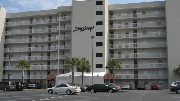 A multi-story hotel with a central entrance and balconies on each floor. - Sunswept 304 by Liquid Life (Orange Beach)