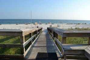 A wooden boardwalk leading to a beach with a clear sky. - Sunswept 305 by Liquid Life (Orange Beach)