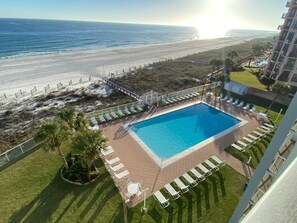A pool area with lounge chairs and a view of the beach. - Sunswept 305 by Liquid Life (Orange Beach)