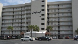 A multi-story hotel with a central entrance and balconies on each floor. - Sunswept 402 by Liquid Life (Orange Beach)