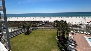 A beach view from a balcony with a pool area and lounge chairs. - Sunswept 403 by Liquid Life (Orange Beach)