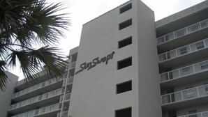 A multi-story hotel building with the name 'SunSept' on the facade. - Sunswept 406 by Liquid Life (Orange Beach)