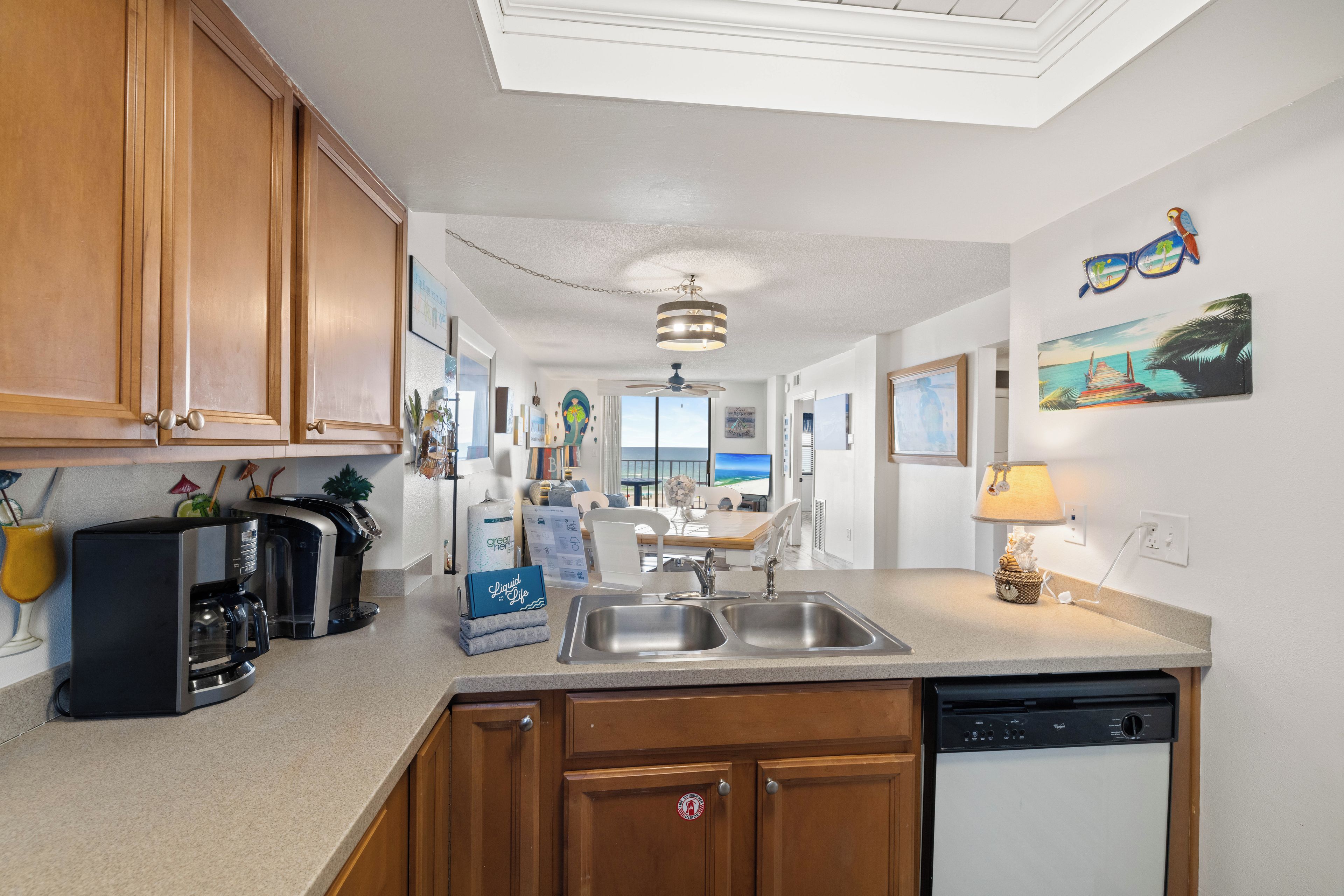 A modern kitchen with wooden cabinets, a coffee maker, and a dishwasher.
