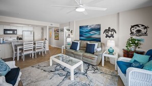 Uma sala moderna com área de jantar, cozinha e ventilador de teto.