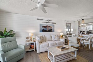 Ein Wohnzimmer mit Sofa, Couchtisch und Deckenventilator.