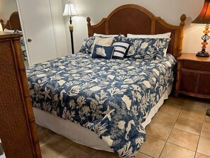 Ein Schlafzimmer mit einem Bett, Nachttischen und einem hölzernen Kopfteil.