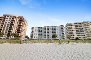 A beachfront hotel with multiple floors, balconies, and a sandy beach in the foreground. - Sunswept 607 by Liquid Life (Orange Beach)