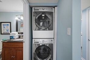A laundry area with two stacked front-loading washing machines. - Sunswept 608 by Liquid Life (Orange Beach)