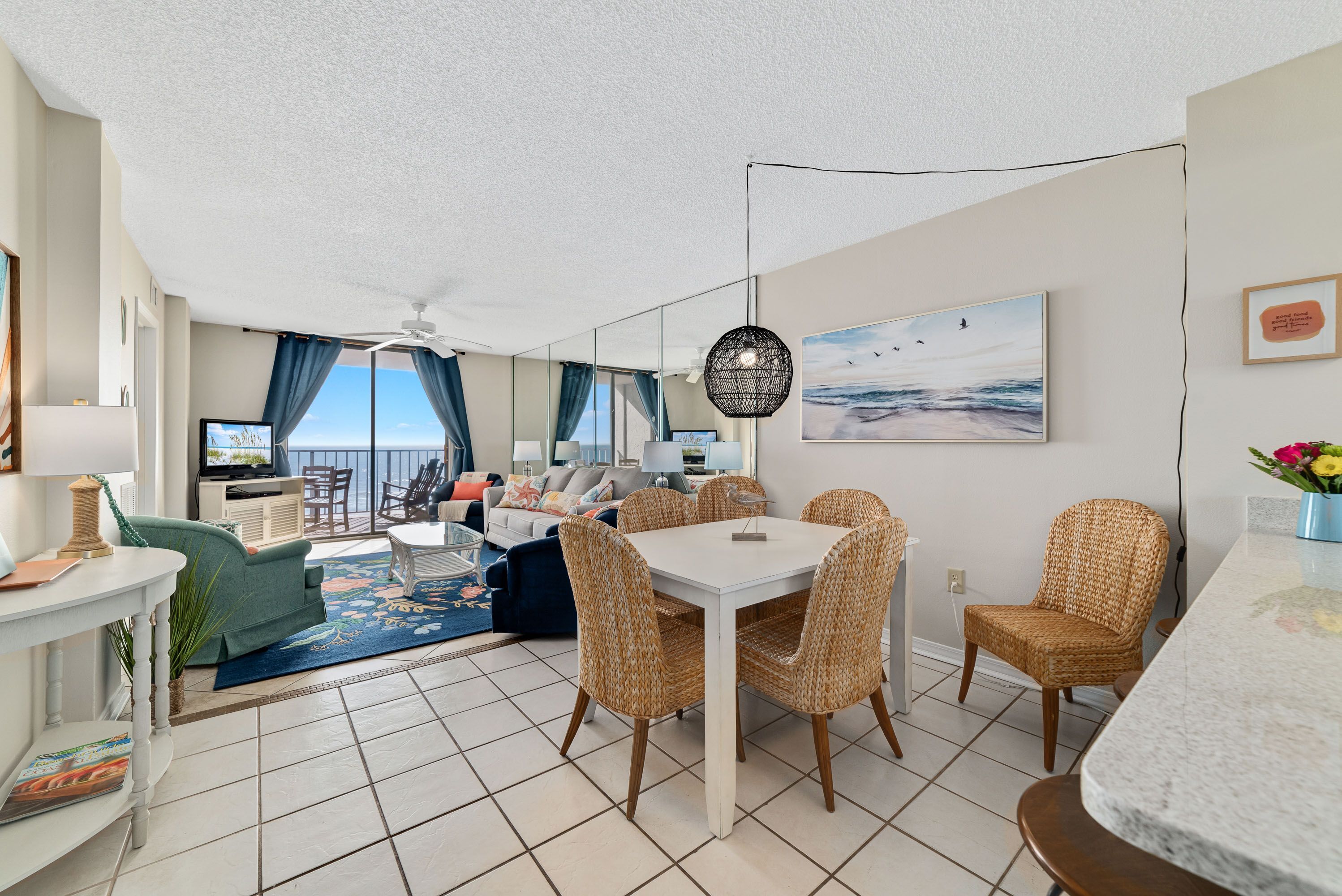 Ein modernes Wohnzimmer mit Essbereich, ein Balkon mit Blick und einem Deckenventilator.