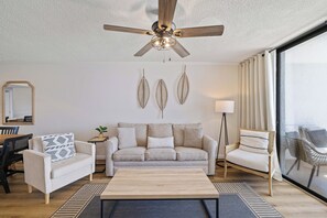 A living room with a ceiling fan, a sofa, two armchairs, a coffee table, and a floor lamp. - Sunswept 707 by Liquid Life (Orange Beach)