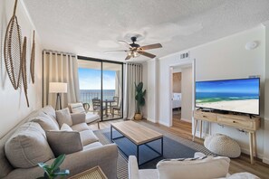 Ein modernes Wohnzimmer mit Sofa, Couchtisch und Fernseher.