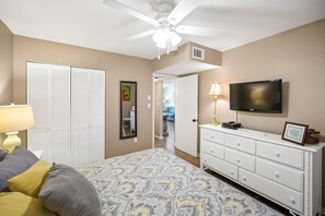 A bedroom with a bed, a dresser, a television, and a closet. - Sunswept 806 Penthouse by Liquid Life (Orange Beach)