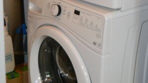 Een gestapelde wasmachine en droger in een wasruimte.