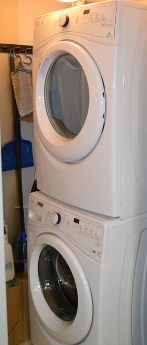 Eine übereinander gestellte Waschmaschine und ein Trockner in einem Waschraum.