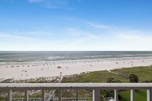 Ein Strand mit blauem Himmel, sandigem Ufer und Blick auf den Ozean.