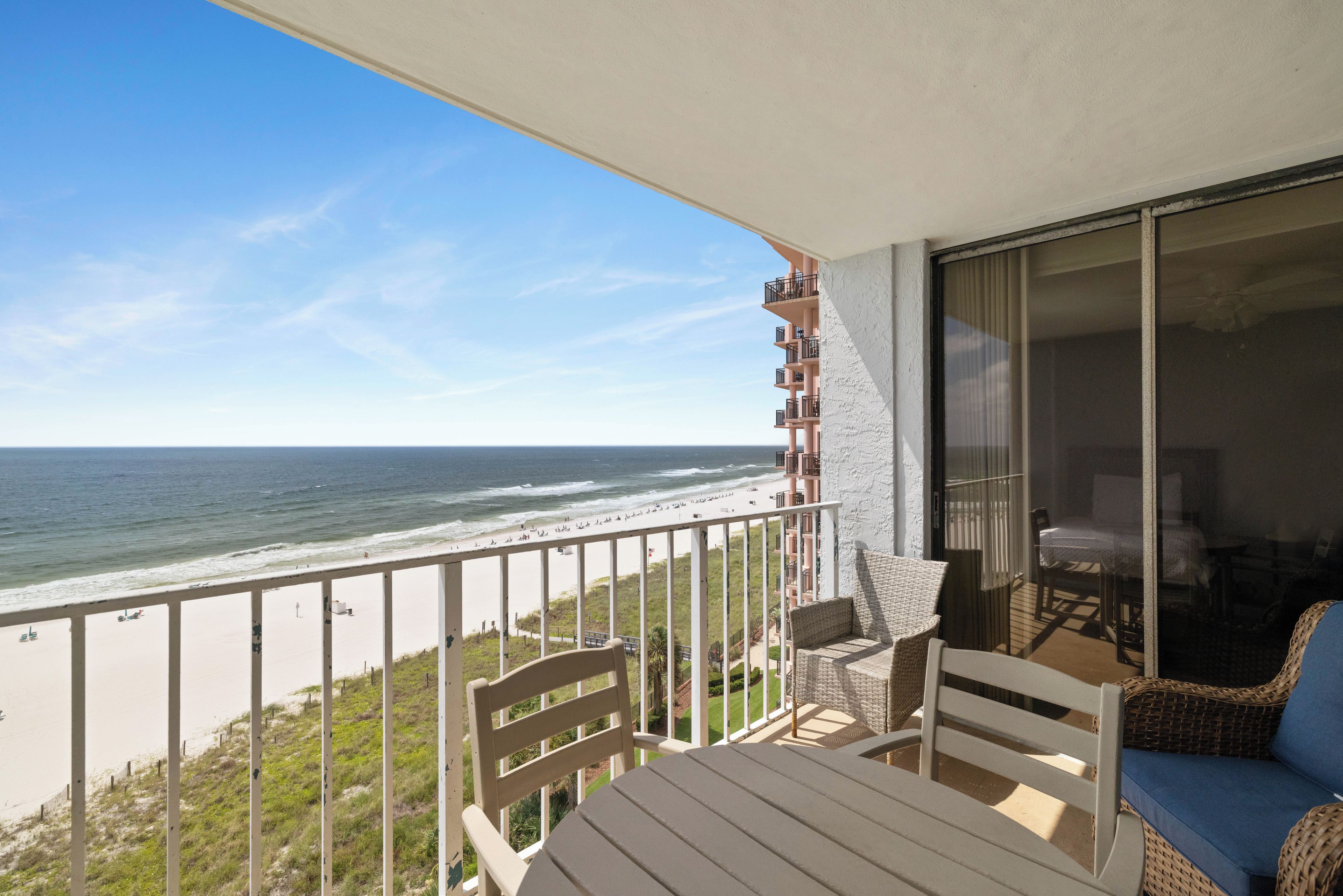 A balcony with a view of the beach and ocean.