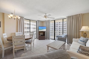 A modern living room with a dining area, a flat-screen TV, and a balcony with a view of the sea. - Seaside Beach & Racquet 4612 by Liquid Life (Orange Beach)