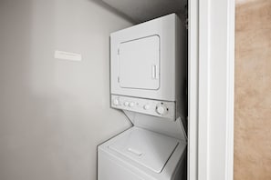 A compact, wall-mounted washing machine with a control panel, indicating a space-saving design likely in a small laundry room. - Seaside Beach & Racquet 5414 by Liquid Life (Orange Beach)