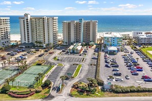 A hotel complex with multiple high-rise buildings, a parking lot, and a beach view. - Shoalwater 604 by Liquid Life (Orange Beach)