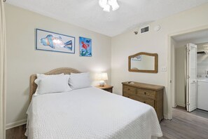 A bedroom with a bed, a nightstand, a dresser, and two wall art pieces. - Shoalwater 604 by Liquid Life (Orange Beach)