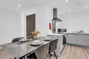 A modern kitchen with a built-in microwave, stove, and ventilation hood. - Stylish & Spacious Anfield Flat | WiFi | Sleeps 4 (Anfield)