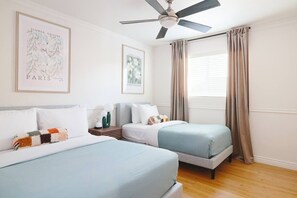 A hotel room with two beds, a ceiling fan, and a window with curtains. - Muse: Scottsdale Home, Pool & Spa (Scottsdale)