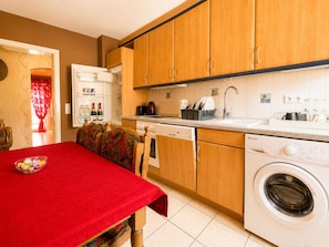 A compact kitchen with wooden cabinets, a built-in dishwasher, and a front-loading washing machine. - Time out Above the Rooftops of Boppard (Boppard)
