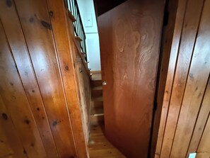 A wooden staircase with a handrail and a door leading to another room. - Driftwood House. Sleeps 4. Beach Access, Parking (Seabrook)