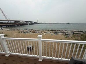 Ein Strand mit einer Holzterrasse und einem weißen Geländer.