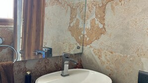 A bathroom with a white sink, a mirror, and a towel rack. - Charming B&B Retreat in the Heart of Cha (Chandigarh)