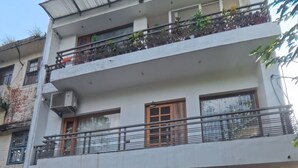 A multi-story residential building with a gated entrance, balconies, and a flat roof. - Charming B&B Retreat in the Heart of Cha (Chandigarh)