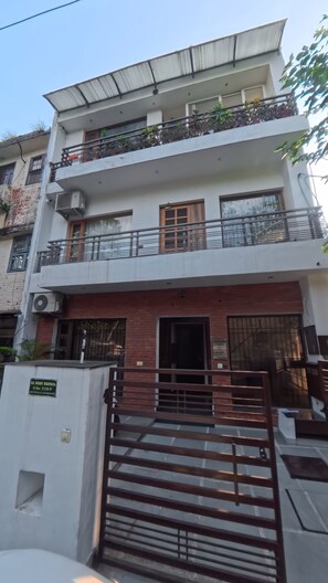 A multi-story residential building with a gated entrance, balconies, and a flat roof. - Charming B&B Retreat in the Heart of Cha (Chandigarh)