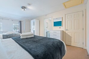 Ein Hotelzimmer mit zwei Betten, einem Badezimmer und Blick nach außen.