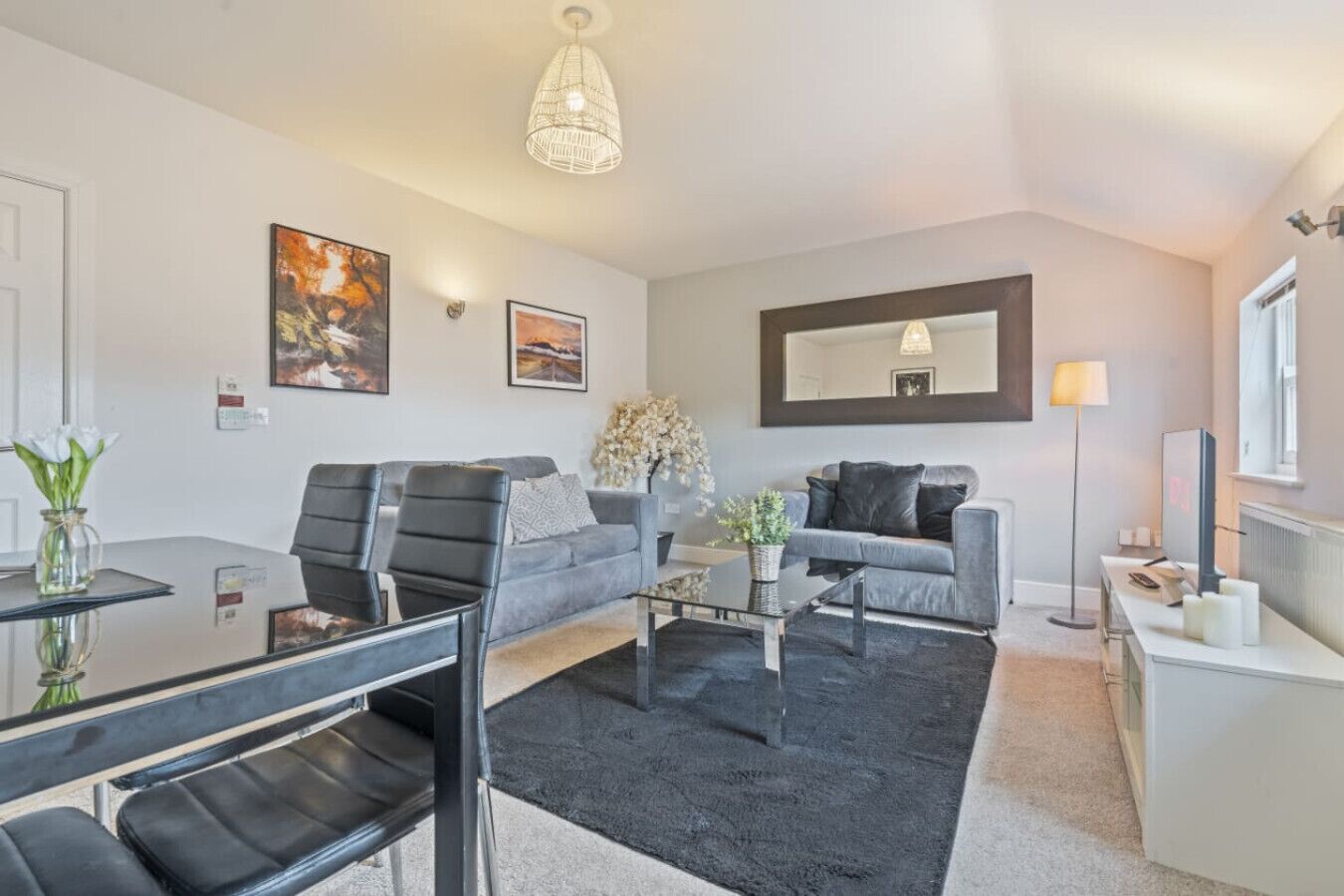 A modern living room with a sofa, coffee table, and dining area.