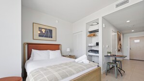 A hotel room with a bed, a bedside table, a chair, a desk, a mirror, and a wardrobe. - The Crosby Balcony Studio Palermo Home (Miami)