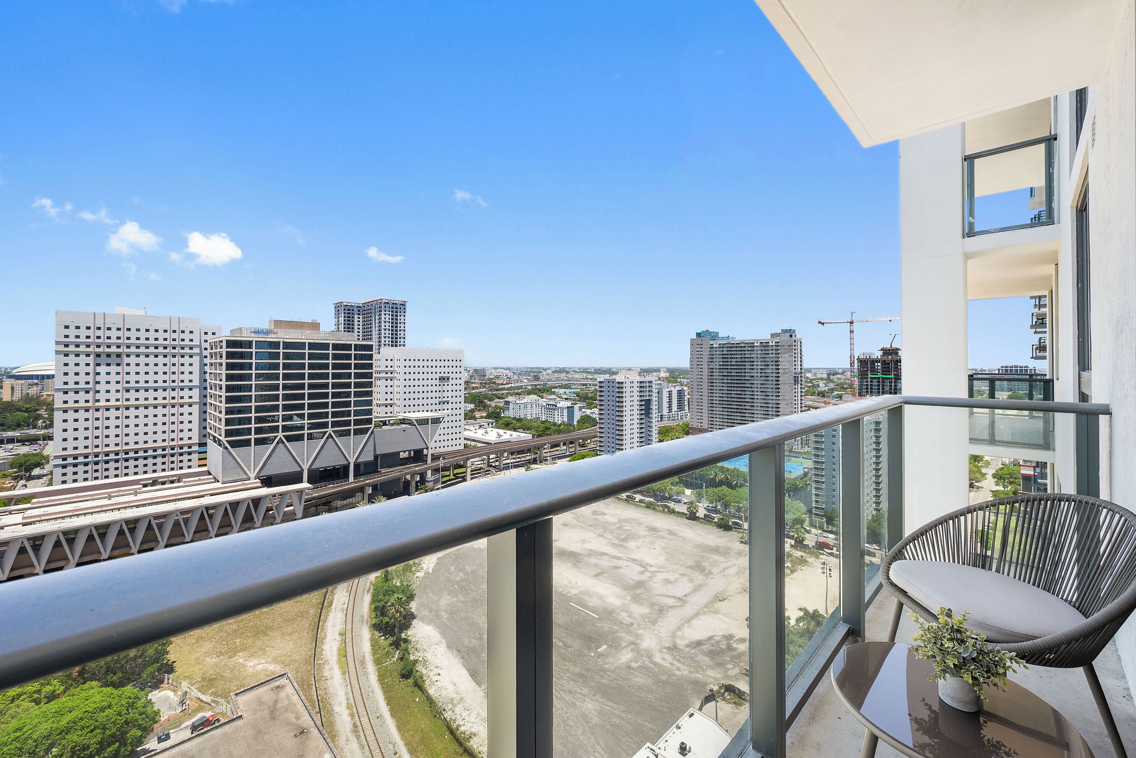 Un balcon offrant une vue sur le paysage urbain, avec notamment des immeubles de grande hauteur et un pont.